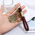 Detail shot of antique bronze owl pendant on red and black braided leather keychain - Cartoon Owl Style (CY045)