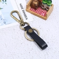 Vintage Bronze Karabiner mit schwarzem Leder Schlüsselanhänger auf weißem Grund - Schwarz