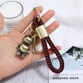 Detail eines Vintage Bronze Bärenanhängers mit rot-schwarz geflochtener Lederkordel - Legierung Bär Stil (CY045)