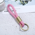 Detailansicht eines rosa geflochtenen Leder-Schlüsselanhängers mit Bronzemetall - Bronze + Rosa Seil