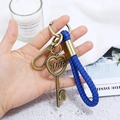 Close-up of deep blue braided leather keychain with bronze heart charms and Love engraving - Key Style (CY045)