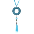 Détail du collier bohème avec pompons bleus et pendentif rond évidé serti de strass - Bleu clair
