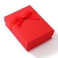 Dettaglio di una scatola regalo rossa per gioielli con fiocco in nastro su carta ruvida - Rosso