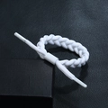 Close-up of a white braided rope bracelet with engraved DPANCO logo aglets on black leather - White