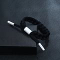 Detail of black woven rope bracelet showing the adjustable buckle and DPANCO logo aglets - Black