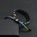 Macro detail of rainbow woven bracelet with Sagittarius zodiac symbol on black sliding buckle - Sagittarius