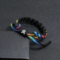 Vue rapprochée du bracelet tressé arc-en-ciel sur coffret cadeau noir avec fermoir réglable - Taureau