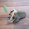 Dettaglio del bracciale multistrato in pelle bianca intrecciata con perline e bottone automatico - Bianco