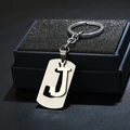 Macro shot of minimalist silver metal letter J keychain on black display box - Letter J / Silver
