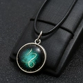 Macro view of Capricorn zodiac necklace with glowing nebula glass gem and bronze base - Capricorn