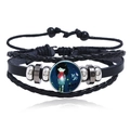 Close-up of multilayer leather bracelet with glowing Capricorn sign glass gem - Capricorn