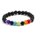 Handmade chakra bracelet with black lava rock beads and colorful healing stones on white backdrop - Lava Stone + Seven Colors