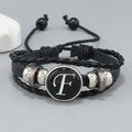 Macro view of multi-layer leather bracelet featuring letter F and metal beads - Letter F