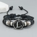 Detail view of multilayer braided leather bracelet with central round letter L glass charm - Letter L