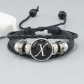 Detail of layered black leather bracelet with silver beads and letter X glass charm - Letter X