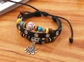 Macro detail of multi-layer leather bracelet with wooden beads and silver flower pendant - Black