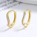 Gouden S-vormige oorringen met glinsterende zirkonia op een minimalistische achtergrond - 925 zilver / Goud/Paar