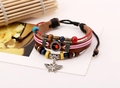 Detail of vintage multilayer leather bracelet with colorful beads and butterfly charm - Brown