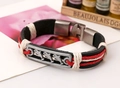 Dettaglio del bracciale in pelle intrecciata con placca in argento antico e delfini - Rosso (Donna)