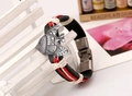 Dettaglio macro del braccialetto in pelle intrecciata con ciondolo a pesce argento vintage - Stile Donna