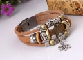 Detalle de pulsera multicapa de cuero con colgantes de estrella, luna y cuentas metálicas - Tostado