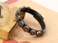 Detail shot of vintage punk black leather bracelet with round metal iron cross rivets - Black