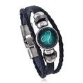 Macro shot of Leo zodiac sign cabochon on a multi-layer black leather braided bracelet - Leo