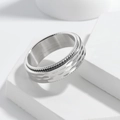 Macro detail of 8mm silver spinner ring featuring hammer texture and industrial gear edges - US 7 / Silver Hammered Spinner
