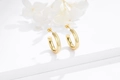 Macro shot of minimalist gold C-shaped hoop earrings on elegant white geometric props - 925 Silver / Gold