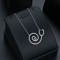 Silver stethoscope necklace with heart pendant on a premium black leather display - Silver