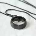 Nahaufnahme eines mattschwarzen Wolframkarbid-Ringanhängers an einer klassischen Perlenkette - Mattschwarzer Ring-Stil (SMXL105) / Schwarz