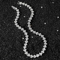 Silver hip hop necklace with icy diamond triangle links on a textured black background - Necklace / Silver / 45 cm