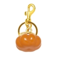 Macro view of orange resin pumpkin charm with polished gold-tone lobster clasp - Pumpkin