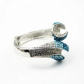 Dettaglio di un bracciale in lega argento con cristalli blu e bianchi e design aperto - Blu