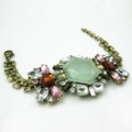 Dettaglio di bracciale vintage in bronzo con grande cristallo verde e pietre multicolori - Verde