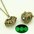 Macro detail of vintage hollow heart locket necklace with green luminous bead inside - Heart Antique Bronze Green Light (YJ10-6073)