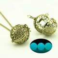 Dettaglio collana a cuore traforato con perla blu luminosa e catena in bronzo vintage - Bronzo Antico Luce Blu (YJ10-6074)