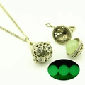 Dettaglio del ciondolo a gabbia vintage con perla verde luminosa che brilla nel buio - Luce Verde (YJ10-6064)