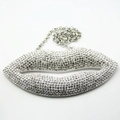 Chunky silver necklace featuring a large red lip pendant with sparkling crystals - White