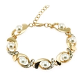 Dettaglio del bracciale dorato con perle, design a onde, strass e chiusura a moschettone - Oro