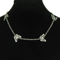 Detalle del collar plateado con cuatro dijes de mariposa calados puesto al cuello - Plata (4 Mariposas)