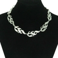 Close-up van gotische punk vlamvormige zilveren ketting op een zwarte sieradenbuste - 8 Vlammen Accessoire Stijl / Zilver
