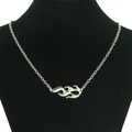 Detail van zilveren vlamvormige hanger met uitsparing op een delicate ketting op een buste - Enkele Vlam Accessoire Stijl / Zilver