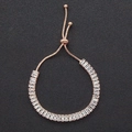 Dettaglio di un bracciale regolabile in oro rosa con zirconi a baguette e chiusura a scorrimento - Oro rosa