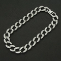 Close-up of iced-out silver Cuban link necklace with sparkling crystals on black foam - Silver Necklace