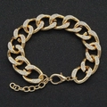Detailed view of a gold Cuban link chain with sparkling pavé-set rhinestones and clasp - Gold - Bracelet