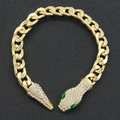 Macro detail of golden Cuban link snake bracelet with sparkling crystals and green eyes - Green Eyes Bracelet / Gold
