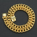Gold Cuban link chain necklace with iced out alien buckle on a textured dark surface - 24inch / Gold
