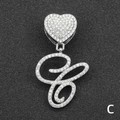 Macro shot of silver heart pendant with letter C and full rhinestone inlay on dark background - Letter C / Silver