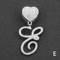 Macro view of crystal encrusted silver heart clasp and cursive letter E pendant - Letter E / Silver